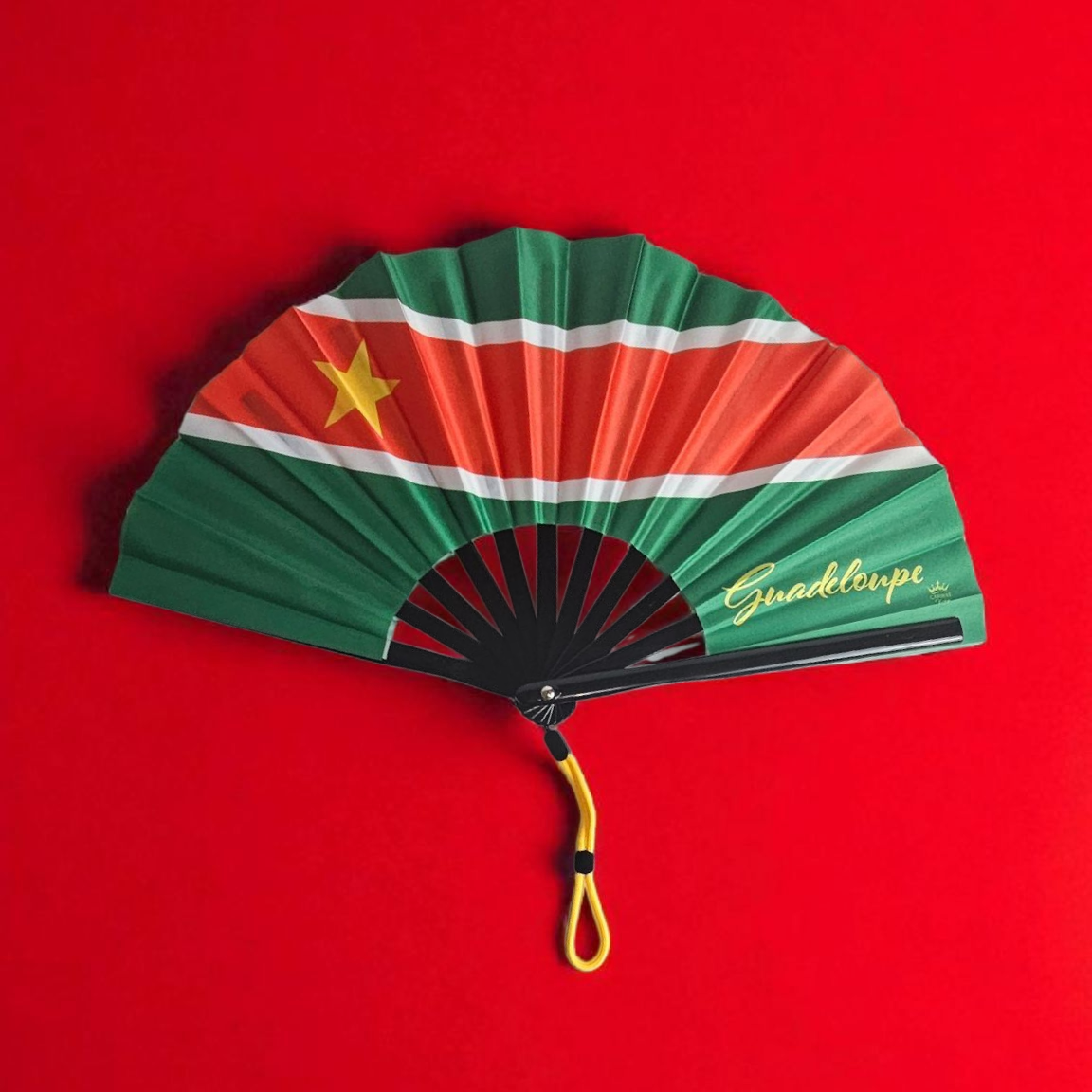 Guadeloupe revolutionary folding fan featuring green top and bottom, red center with white borders, and gold star on the left – cultural accessory by Caribae Kiss