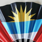 Close up of Antigua Barbuda flag inspired bamboo folding hand fan.  Close up of the nations flag emblem displaying sun.