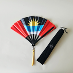 Antigua Barbuda flag inspired bamboo folding hand fan halfway open along with black suede satchel bag with Caribae Kiss white logo print.