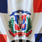 Close up of Dominican Republic flag inspired bamboo folding hand fan.  Close up of the national emblem, Dio Patria Libertad Republica Dominicana