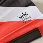 Close up of dual heritage Jamaica and Trinidad & Tobago flag inspired bamboo folding hand fan.  Close up Caribae Kiss logo.