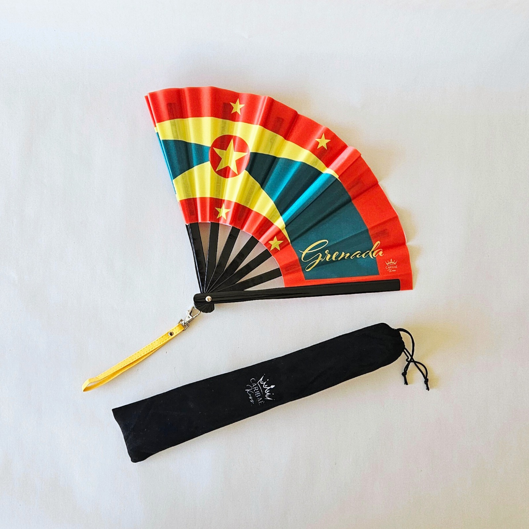 Grenada flag inspired bamboo folding hand fan halfway open along with black suede satchel bag with Caribae Kiss white logo print.