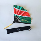 Guadeloupe flag inspired bamboo folding hand fan halfway open along with black suede satchel bag with Caribae Kiss white logo print.