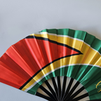 Close up of Guyana flag inspired bamboo folding hand fan.  Close up of the national emblem of the arrowhead
