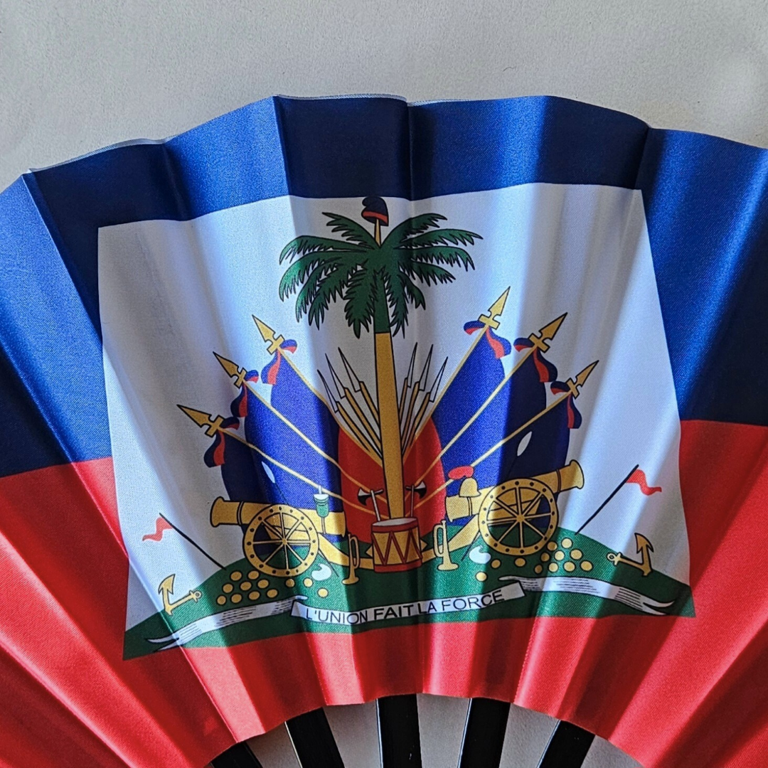 Close up of Haiti "Ayiti" flag inspired bamboo folding hand fan.  Close up of the national emblem L'Union Fait La Force
