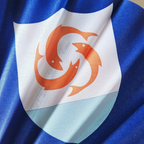 Close up of Anguilla flag inspired bamboo folding hand fan.  Close up of the nations flag emblem of the three fish shield.